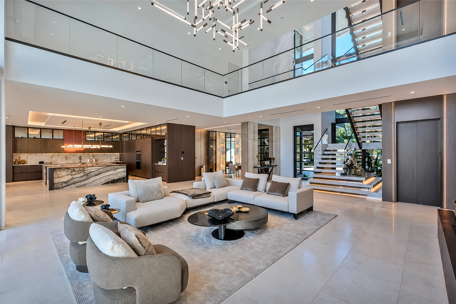 Double-height great room with sculptural chandelier and open staircase