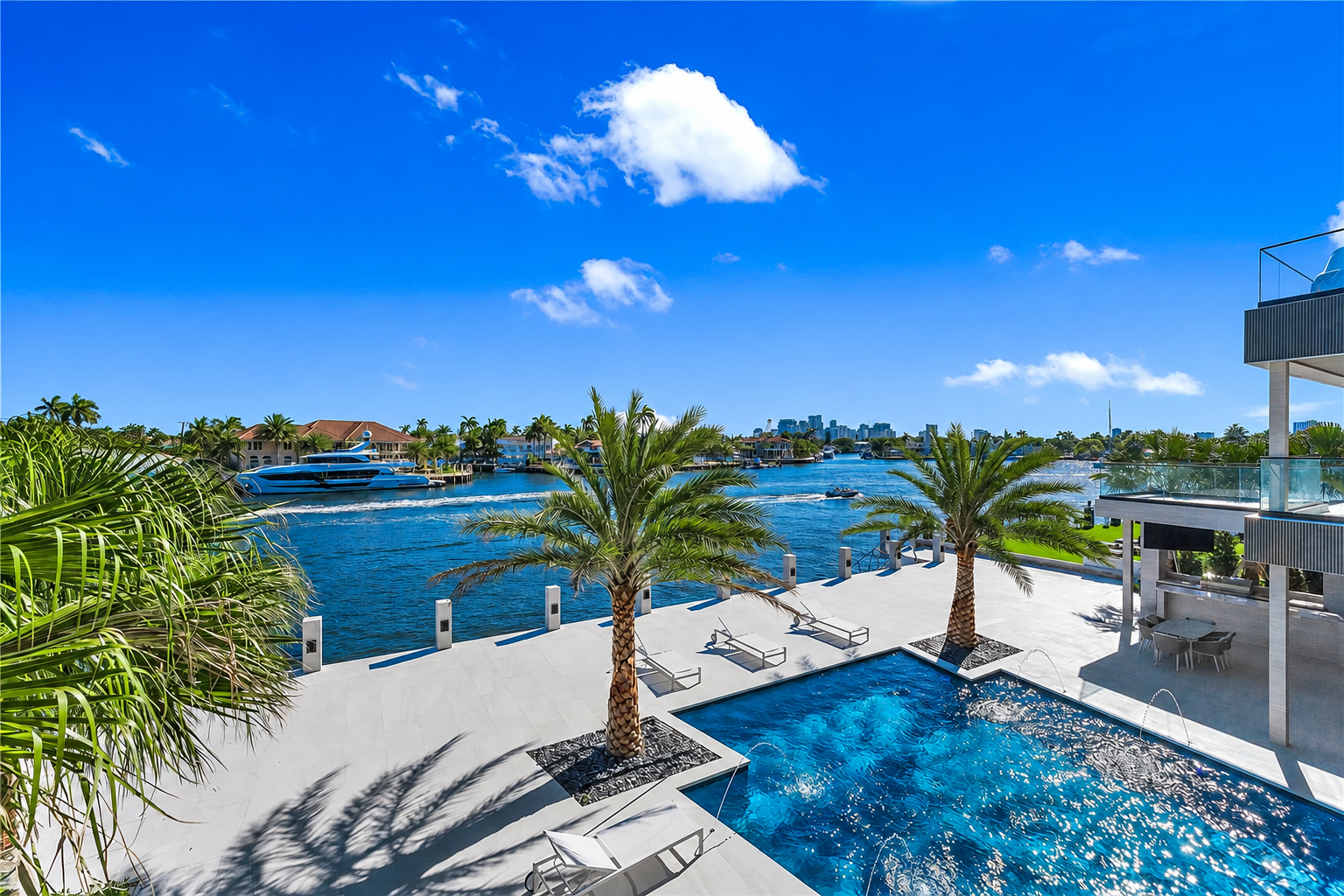 Waterfront pool terrace with palm trees overlooking the intracoastal waterway